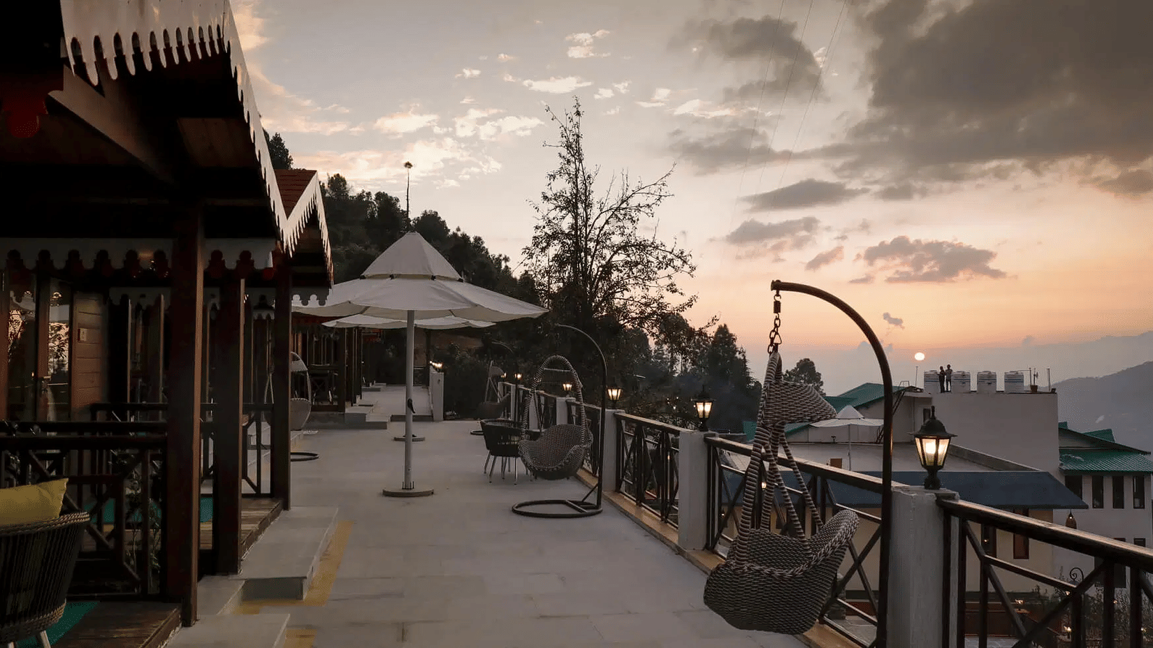 A hotels outdoor dining or lounge area on a balcony with stunning mountain views at sunset, perfect for enjoying the scenery